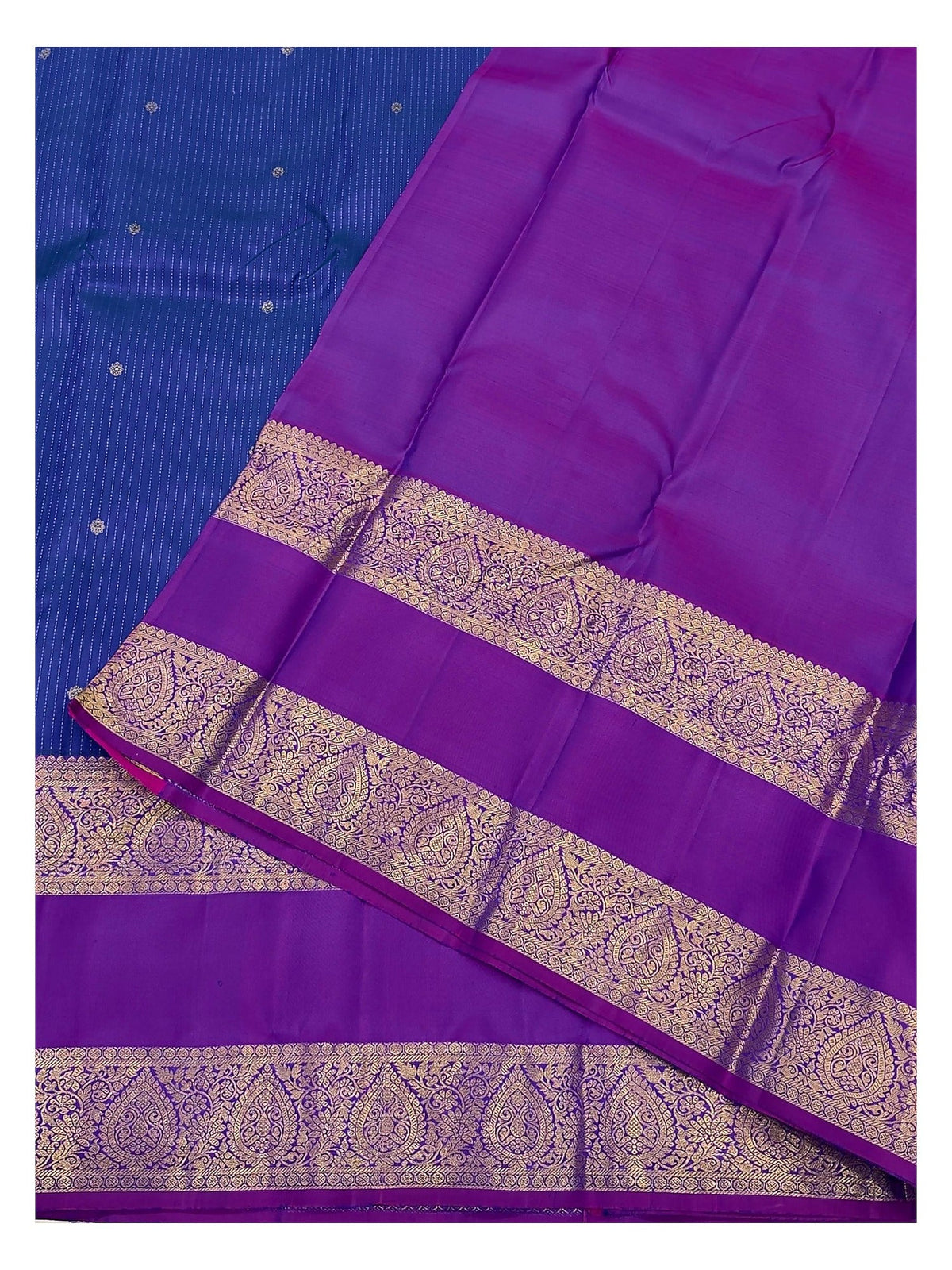 Close view of the magenta pallu with ornate gold-toned woven border and royal blue saree body