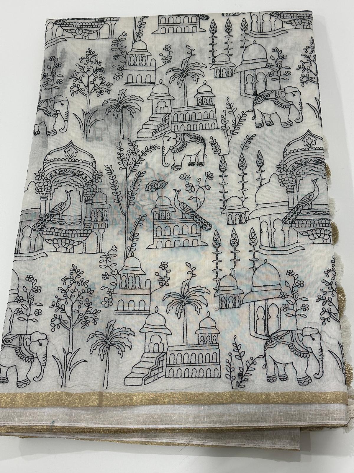 Off white fancy cotton saree with black motif work, artistic detailing, and thin golden border