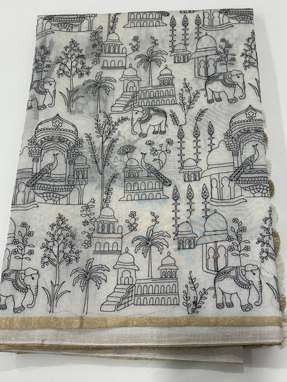 Off white fancy cotton saree with black motif work, artistic detailing, and thin golden border