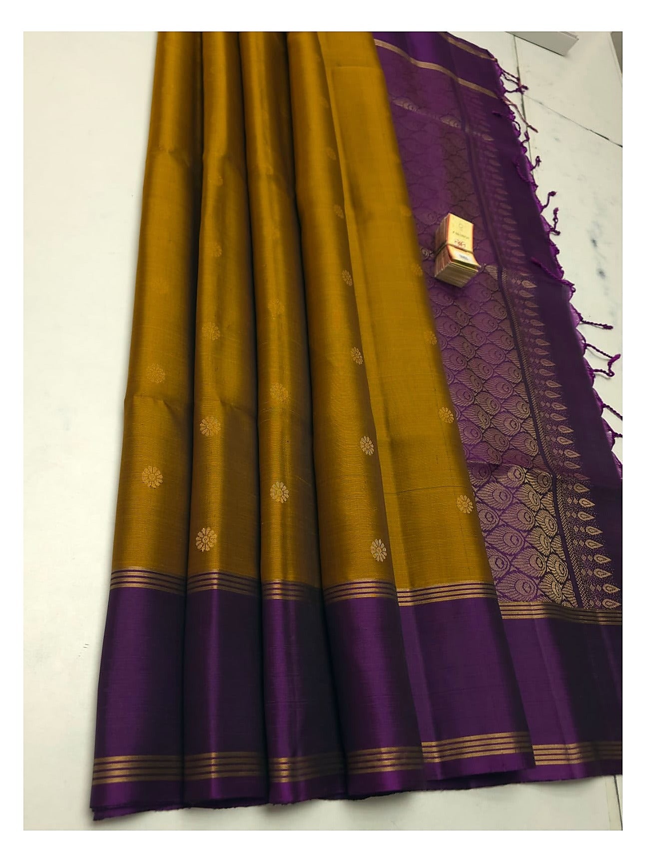 Mustard gold soft silk saree with deep purple contrast border and small woven buttas