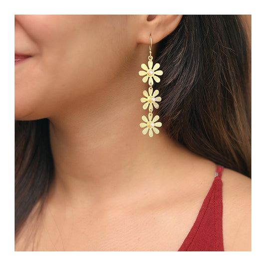 Gold-toned textured triple flower drop earrings worn on ear