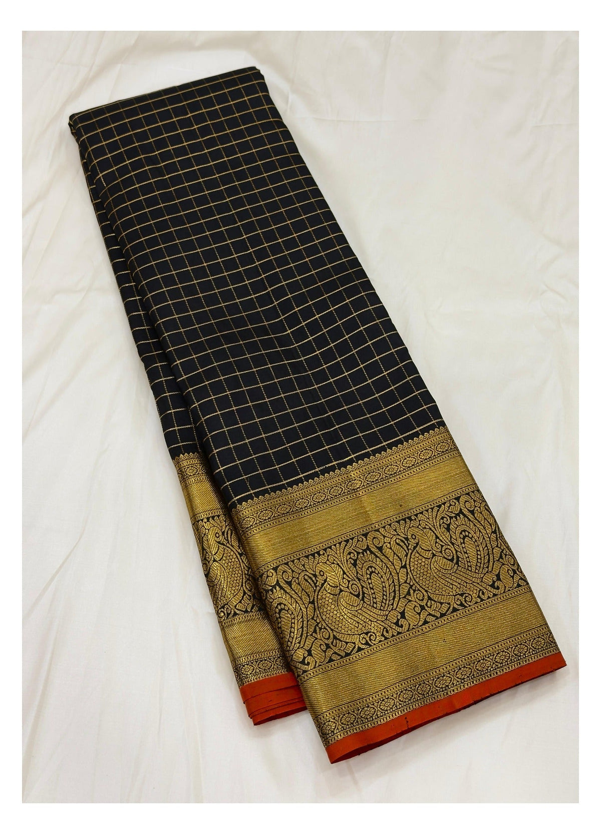 Handwoven Kanchipuram silk saree with black checked body, gold-toned border, and folded contrast edge
