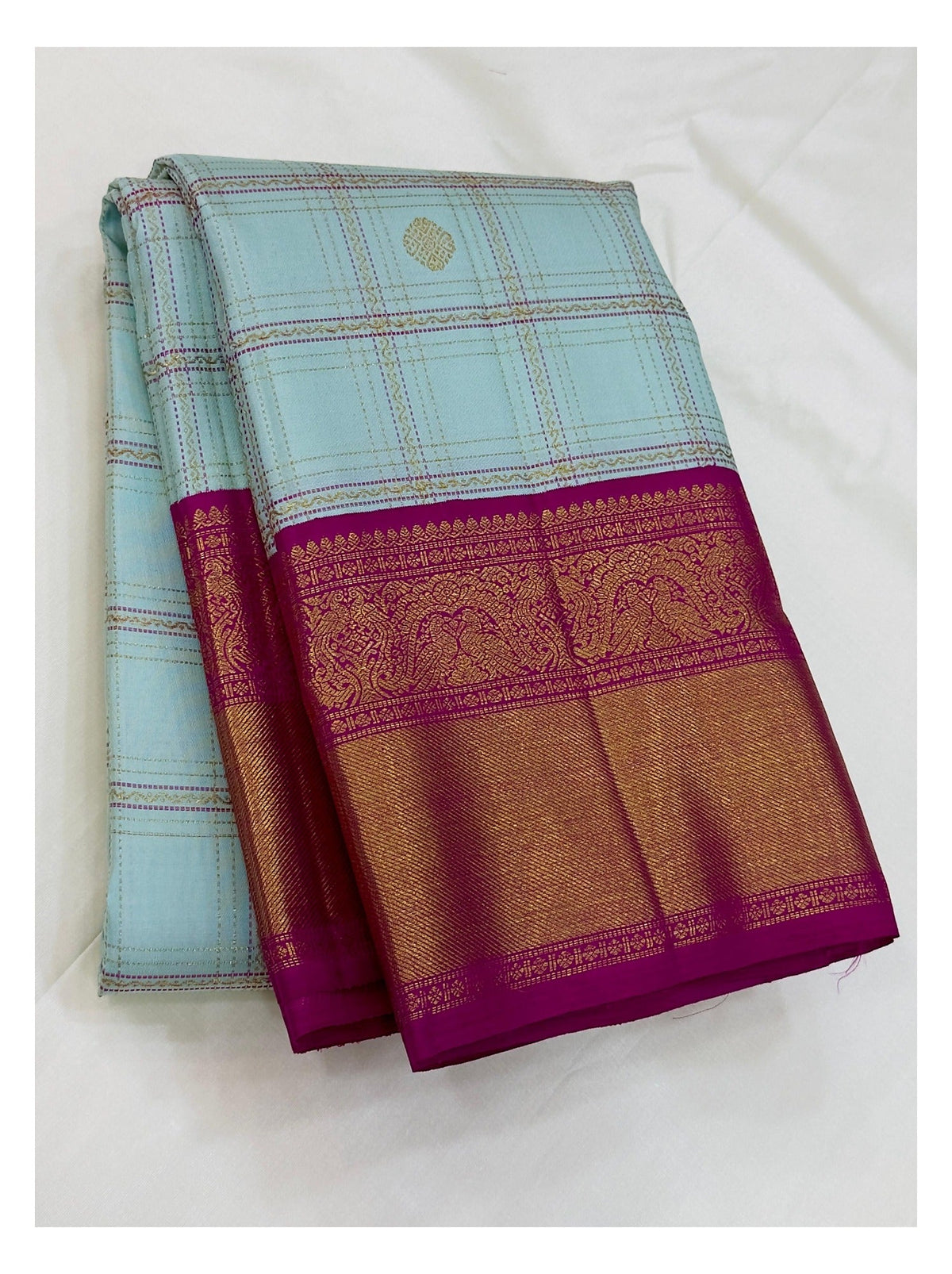 Folded handwoven Kanchipuram silk saree in ice blue checks with magenta border