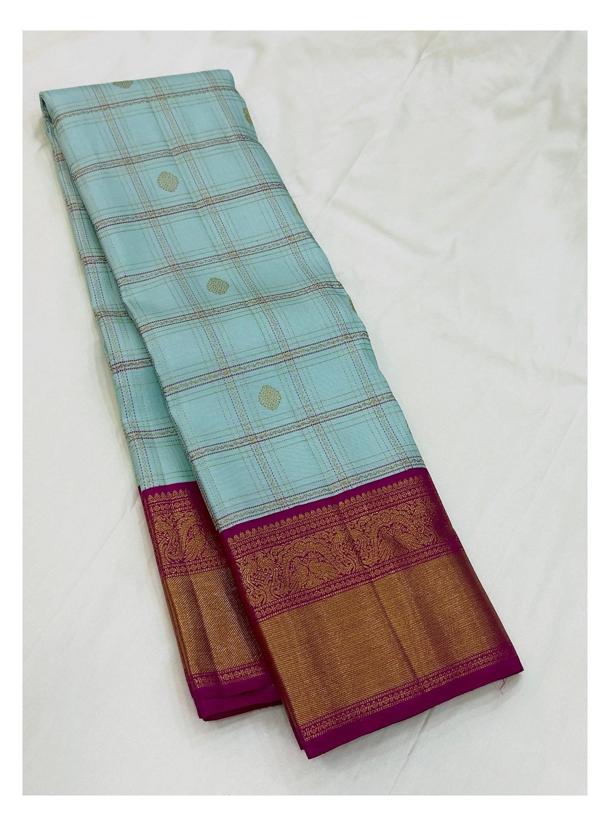 Full folded view of handwoven Kanchipuram silk saree in ice blue checks with magenta border