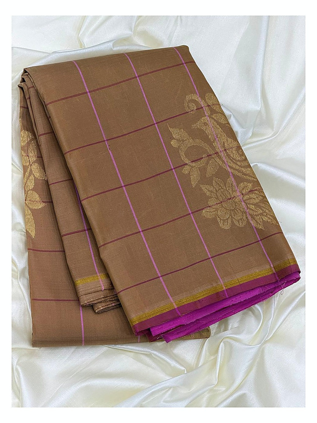 Folded cocoa brown Kanchipuram silk saree with magenta checks and floral woven motif detail