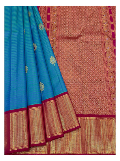 Teal blue saree drape with gold-toned motifs and richly woven contrast pallu