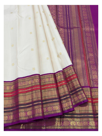 Detailed view of the ivory saree border and magenta pallu with gold-toned woven motifs