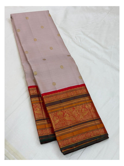 Full folded view of blush pink handwoven Kanchipuram silk saree with red border and gold buttas