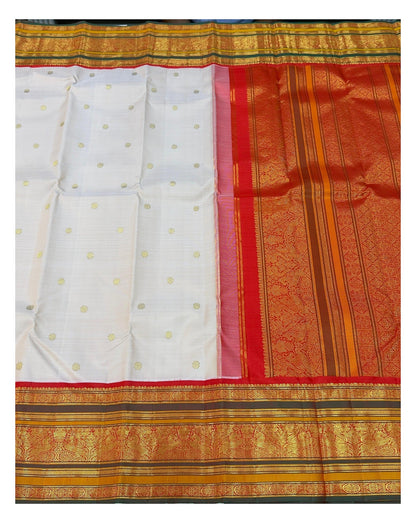 Open view of the saree showing blush pink body with gold-toned buttas and richly woven red pallu