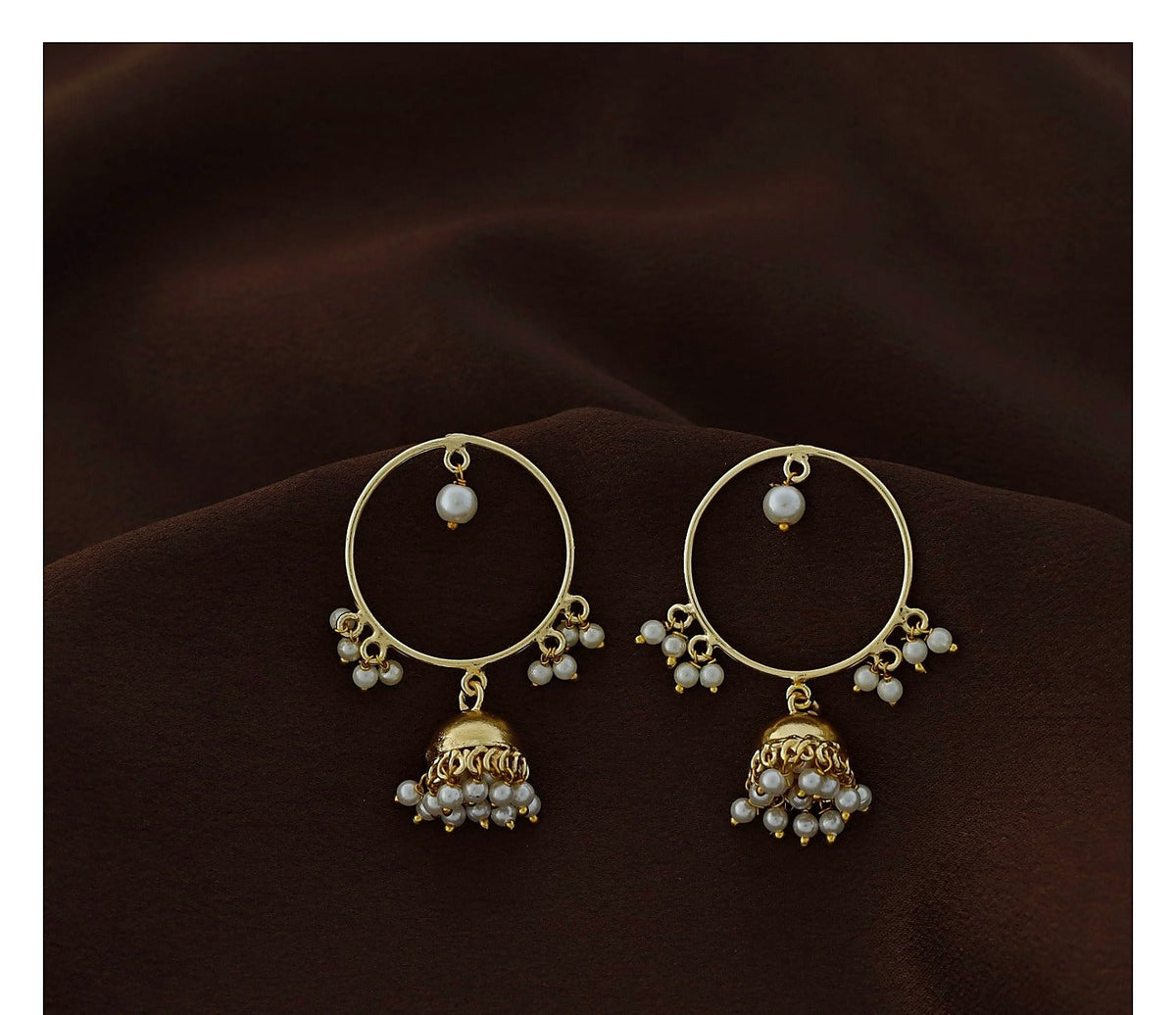 Gold polish circle jhumka earrings with pearl bead detail on dark brown fabric