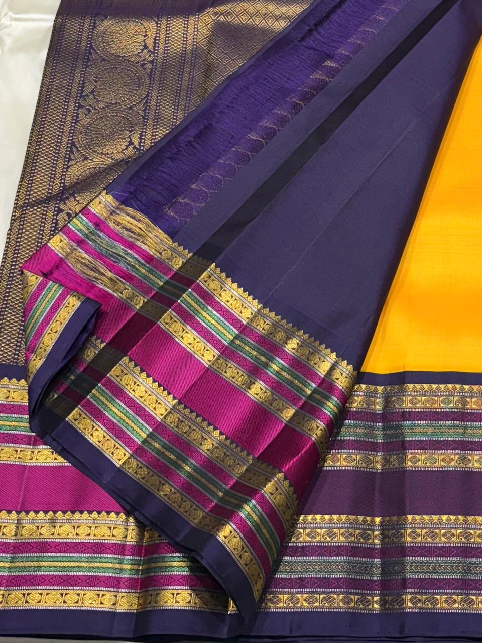 Close-up of mustard yellow pure silk saree with zari motifs and purple border