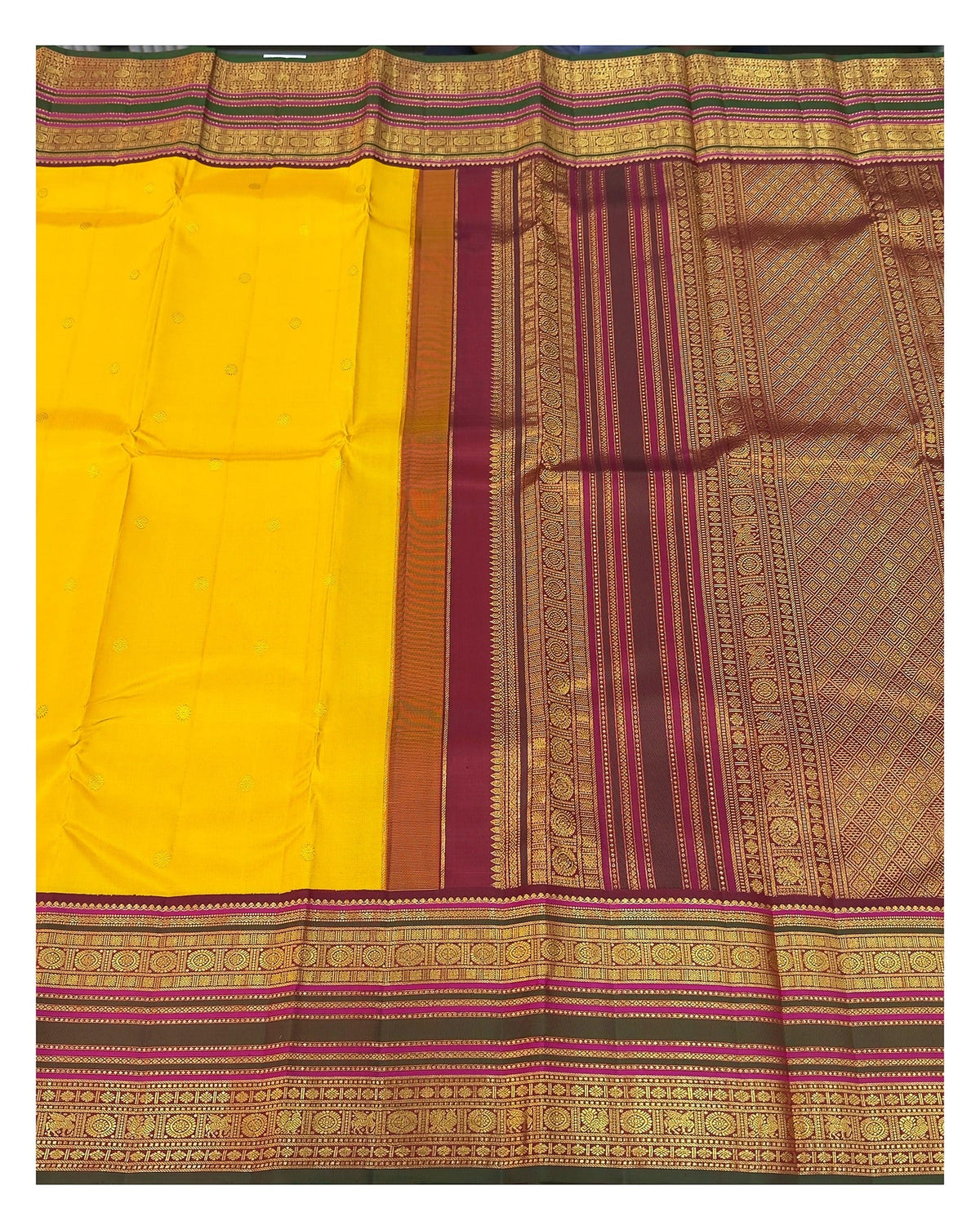Handwoven Kanchipuram silk saree spread open to show mustard body, broad border and richly woven pallu
