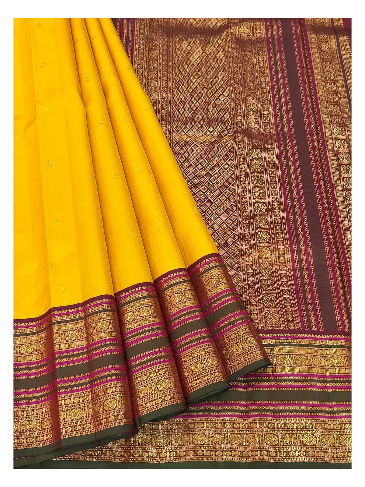 Pleated view of the mustard yellow handwoven Kanchipuram silk saree with magenta border and woven pallu