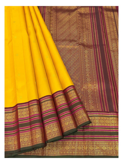 Pleated view of the mustard yellow handwoven Kanchipuram silk saree with magenta border and woven pallu