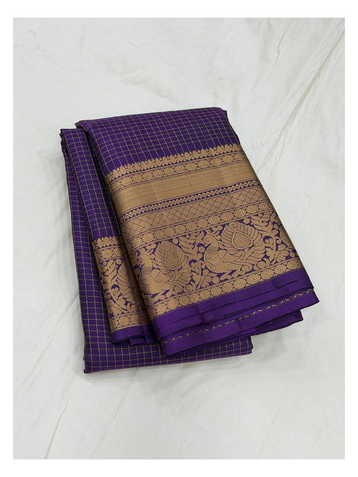 Royal purple pure silk saree with gold zari woven border shown folded