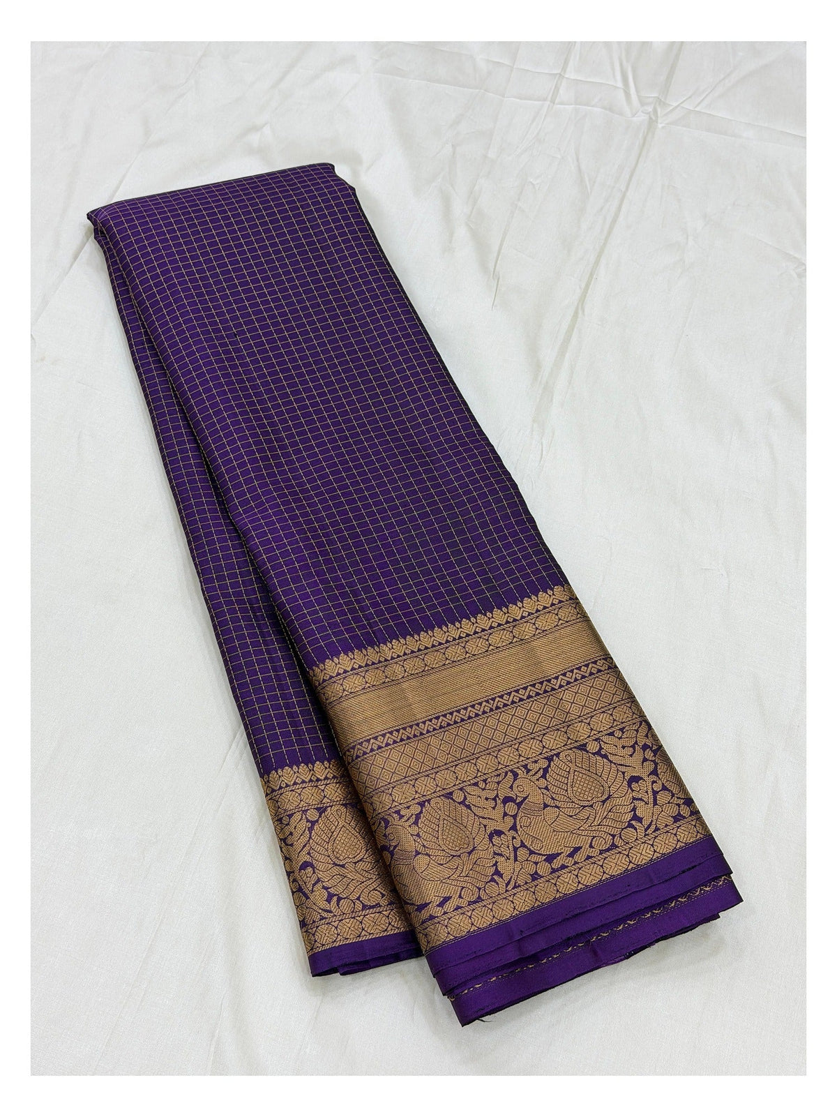 Royal purple pure silk saree with gold zari border shown unfolded